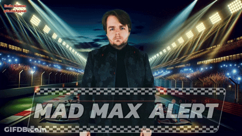 A Man In A Black Jacket Stands In Front Of A Sign That Says Mad Max Alert GIF