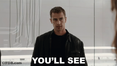 A Man In A Black Jacket Stands In Front Of A Sign That Says " You 'Ll See " GIF