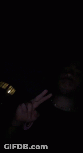 A Man In A Black Jacket Stands In The Dark GIF