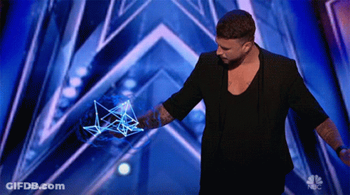 A Man In A Black Jacket Stands On A Stage With A Nbc Logo In The Corner GIF
