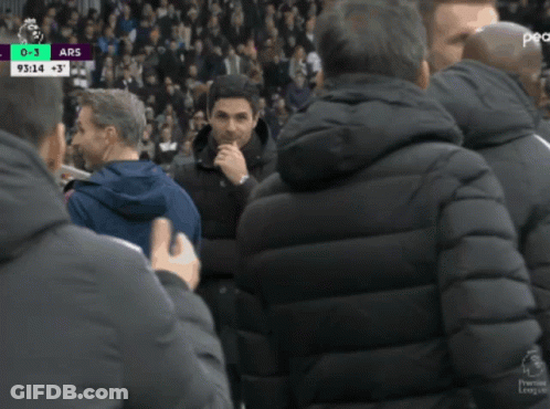 A Man In A Black Jacket Talks To Another Man In A Blue Jacket GIF
