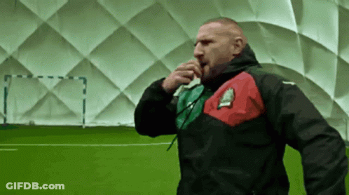 A Man In A Black Jacket With A Red And Green Stripe On The Sleeve GIF