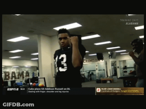 A Man In A Black Jersey With The Number 13 On It Stands In A Gym GIF