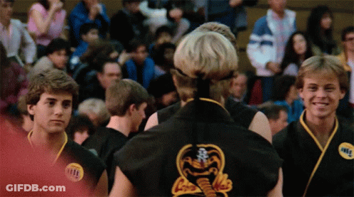 A Man In A Black Karate Uniform Has A Sticker On His Chest That Says Karate GIF