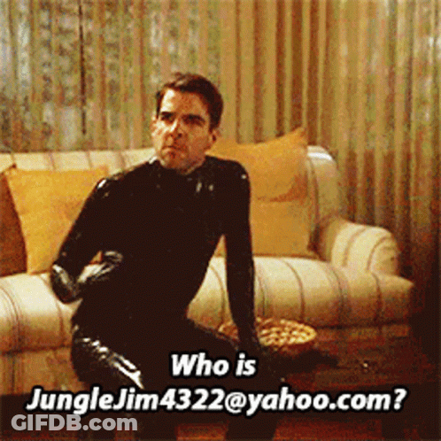 A Man In A Black Latex Suit Is Sitting On A Couch And Asking Who Is Jungle Jim4322@yahoo.com GIF