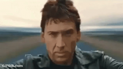 A Man In A Black Leather Jacket Is Riding A Motorcycle On A Road . GIF