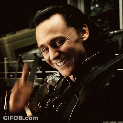 A Man In A Black Leather Jacket Is Smiling And Waving His Hand . GIF