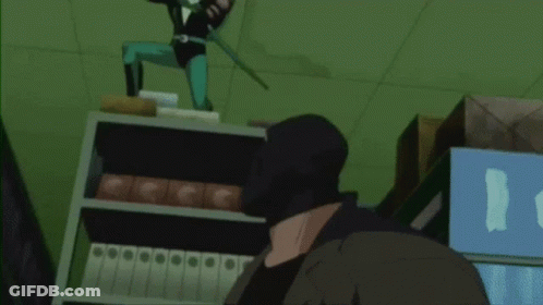 A Man In A Black Mask Is Standing In Front Of A Shelf With Binders GIF