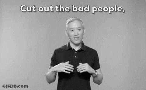 A Man In A Black Polo Shirt Is Standing In Front Of A Gray Background . GIF