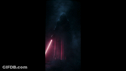 A Man In A Black Robe Holding A Red Light Saber GIF