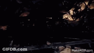 A Man In A Black Robe Is Standing In Front Of A Group Of Monsters In A Dark Room . GIF
