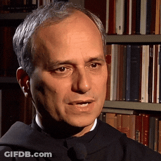 A Man In A Black Robe Stands In Front Of A Bookshelf With A Book Titled ' A Brief History ' On It GIF
