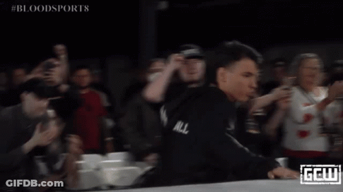 A Man In A Black Robe Stands In Front Of A Crowd With The Word Bloodsports On The Bottom Right GIF