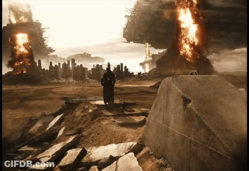A Man In A Black Robe Stands On A Rock In Front Of A Burning City GIF