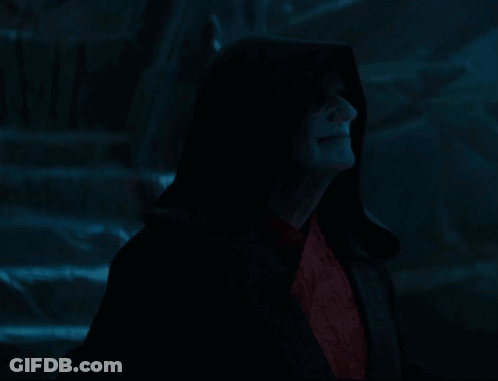A Man In A Black Robe With A Hood And Red Eyes GIF