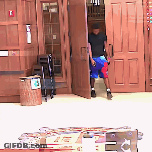 A Man In A Black Shirt And Blue Shorts With The Number 2 On Them GIF