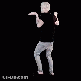 A Man In A Black Shirt And Jeans Is Dancing With His Hands In The Air . GIF