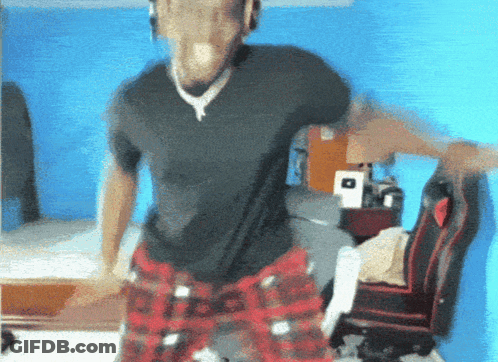 A Man In A Black Shirt And Plaid Pants Is Dancing In A Bedroom GIF