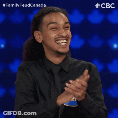 A Man In A Black Shirt And Tie With A Name Tag That Says Raheem GIF