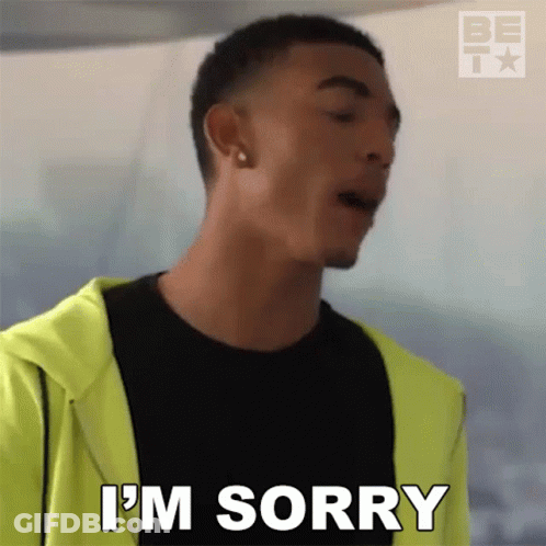 A Man In A Black Shirt And Yellow Jacket Is Saying I 'M Sorry GIF