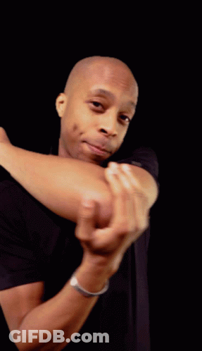 A Man In A Black Shirt Holds His Elbow Up In Front Of His Face GIF