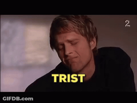 A Man In A Black Shirt Is Crying With The Word Trist In The Background . GIF