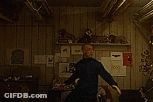 A Man In A Black Shirt Is Dancing In A Room GIF