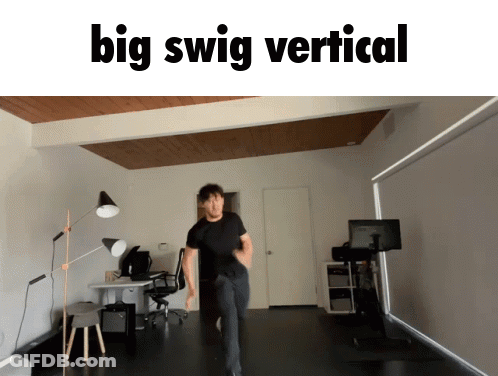 A Man In A Black Shirt Is Dancing In A Room With The Words Big Swig Vertical Below Him GIF