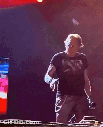 A Man In A Black Shirt Is Dancing In Front Of A Red Light GIF