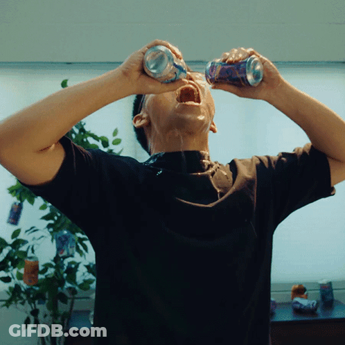 A Man In A Black Shirt Is Drinking From Two Cans With His Mouth Open GIF
