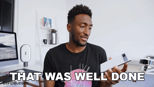 A Man In A Black Shirt Is Holding A Cell Phone And Says " That Was Well Done " GIF