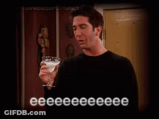 A Man In A Black Shirt Is Holding A Martini Glass . GIF