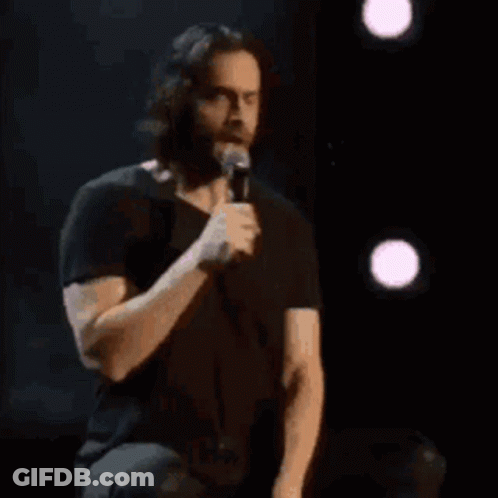 A Man In A Black Shirt Is Holding A Microphone And Says Sign Me Uppppp GIF