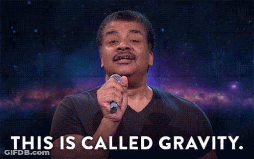 A Man In A Black Shirt Is Holding A Microphone In His Hand And Says This Is Called Gravity . GIF