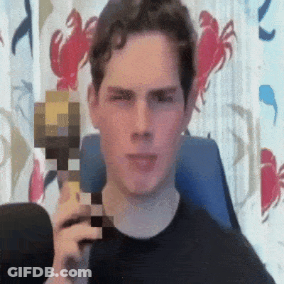 A Man In A Black Shirt Is Holding A Minecraft Block In Front Of His Face . GIF