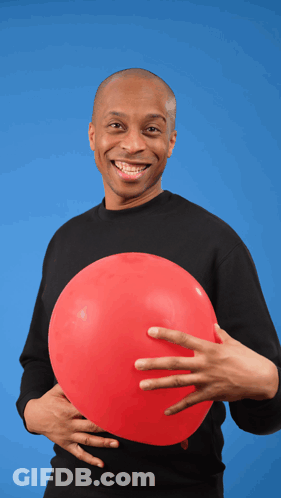 A Man In A Black Shirt Is Holding A Red Balloon In His Hand GIF