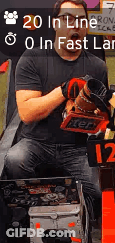 A Man In A Black Shirt Is Holding A Tool And A Sign That Says ' 20 In Line 0 In Fast Lane ' GIF