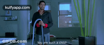 A Man In A Black Shirt Is Holding A Vacuum Cleaner And Says You Are Such A Child . GIF