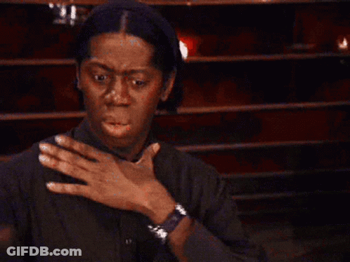 A Man In A Black Shirt Is Holding His Chest With His Hands . GIF