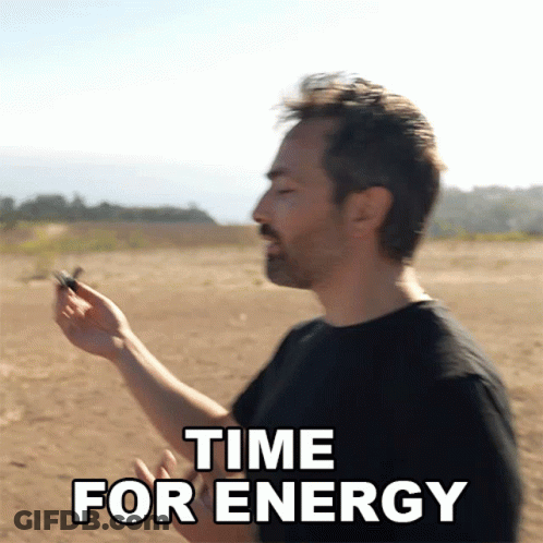 A Man In A Black Shirt Is Holding Something In His Hand With The Words Time For Energy Below Him GIF