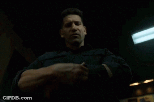 A Man In A Black Shirt Is Holding Something In His Hands GIF