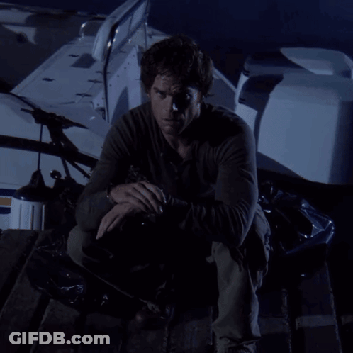 A Man In A Black Shirt Is Kneeling On A Boat In The Dark GIF