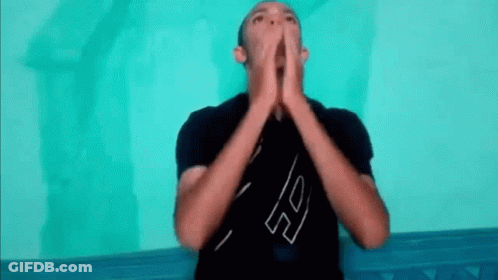 A Man In A Black Shirt Is Making A Funny Face With His Hands Together . GIF