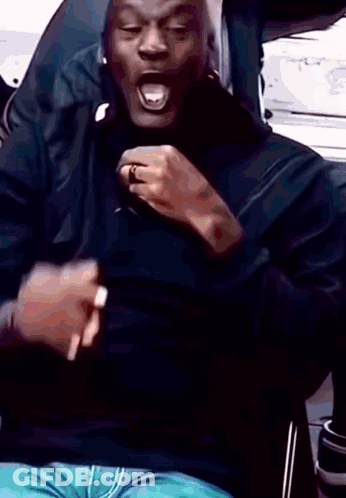 A Man In A Black Shirt Is Making A Funny Face GIF
