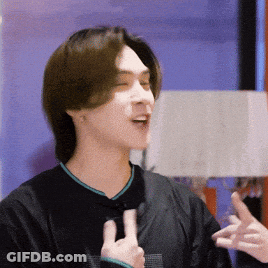 A Man In A Black Shirt Is Making A Peace Sign With His Hands GIF