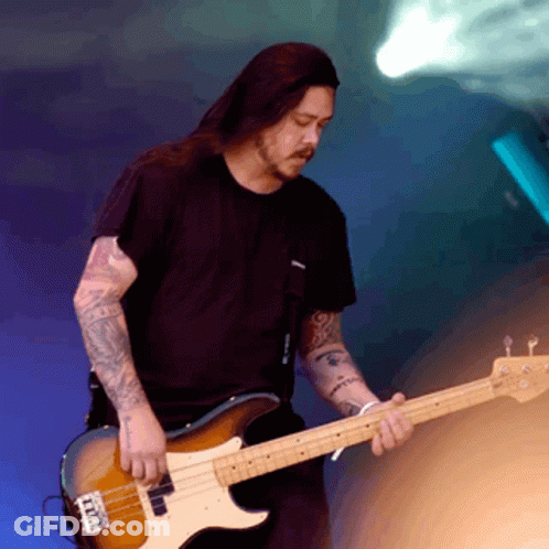 A Man In A Black Shirt Is Playing A Bass Guitar With A Blue Background GIF