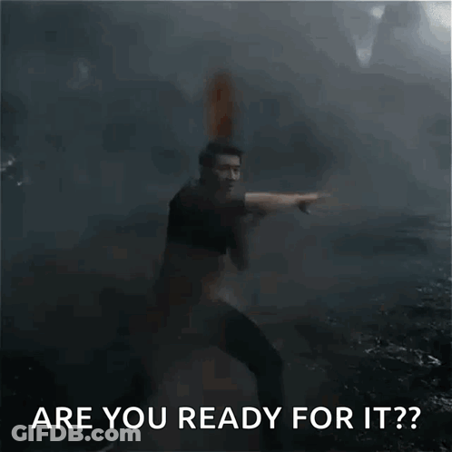 A Man In A Black Shirt Is Pointing At Something In The Dark . GIF