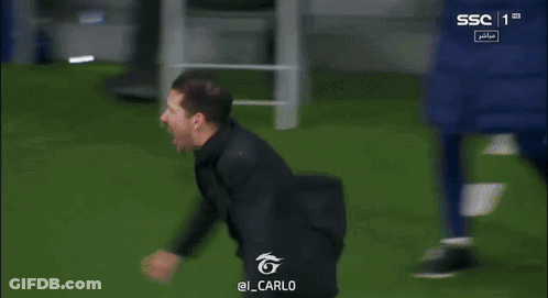 A Man In A Black Shirt Is Running On A Soccer Field GIF