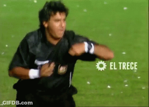 A Man In A Black Shirt Is Running On A Soccer Field With El Trece Written On The Bottom GIF