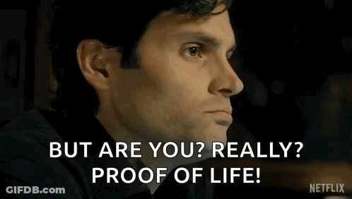 A Man In A Black Shirt Is Sitting In A Room And Says `` But Are You Really ? Proof Of Life ! '' GIF